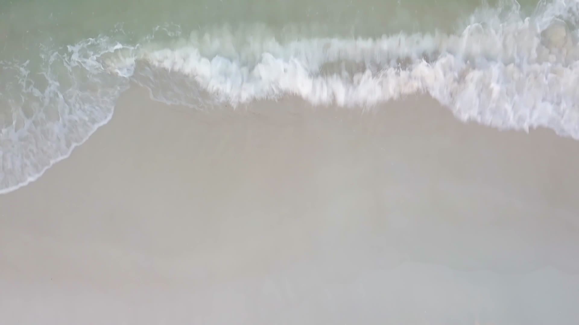 白色的浪花冲向海滩沙滩4k视频的预览图