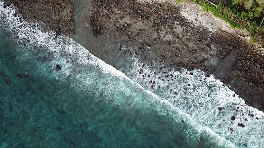 4k海浪拍向礁石冲击海岸浪花沙滩视频的预览图