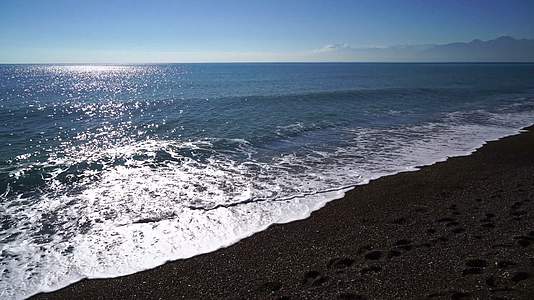大海边浪花冲向沙滩海边岩石4k视频视频的预览图