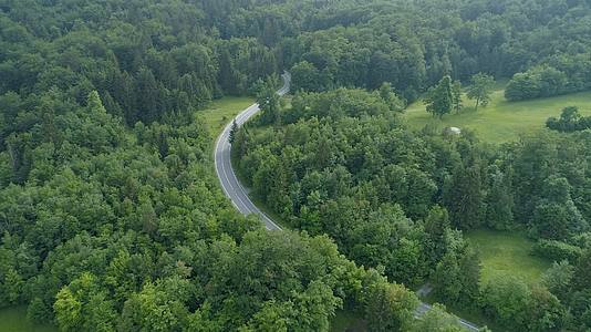 航拍贯穿茂密森林公路汽车辽阔自然美景视频视频的预览图