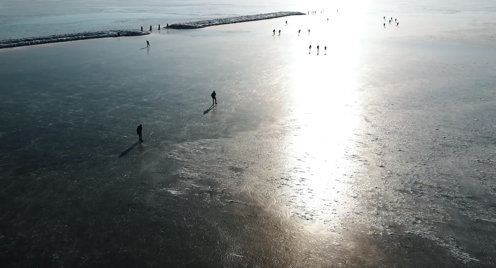 冬季人群玩耍湖面滑冰航拍视频的预览图