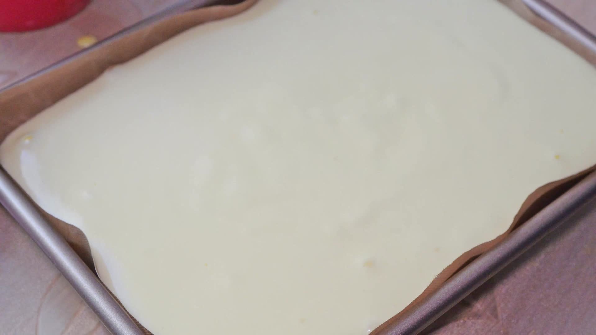 烤老式蛋糕卷面糊倒入烤盘震荡排气视频的预览图