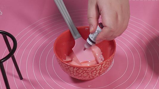 霜糖奶油加入食用色素装入裱花袋视频的预览图