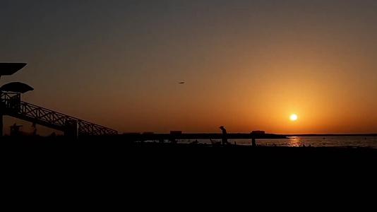 海边沙滩夕阳落日人群唯美延时视频的预览图
