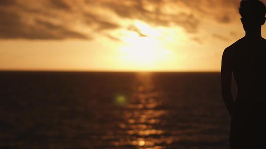 男子傍晚海边夕阳唯美剪影视频的预览图