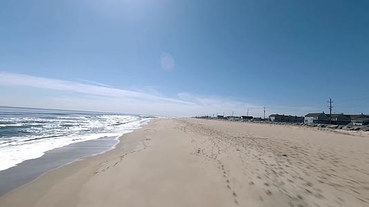 阳光明媚海边沙滩穿越机航拍视频的预览图