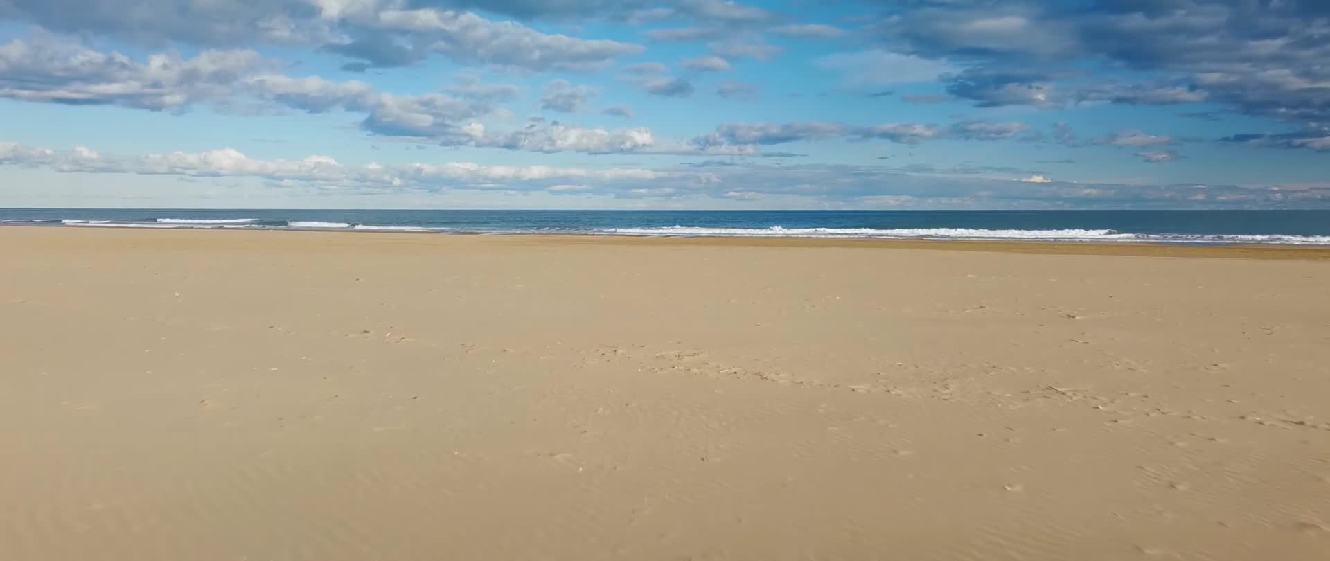 阳光明媚海浪拍打沙滩视频的预览图
