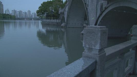 春雨下傍晚都市古镇桥边钓鱼人视频视频的预览图