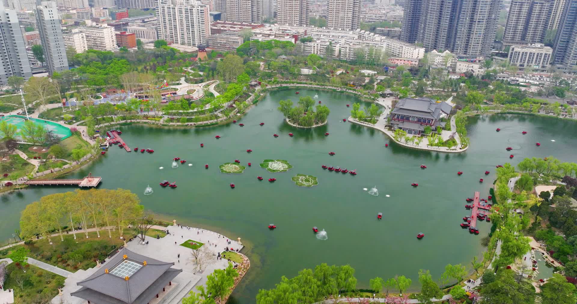 航拍陕西西安兴庆公园人工湖延时游船春季视频的预览图