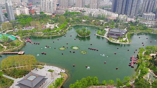 航拍陕西西安兴庆公园人工湖延时游船春季视频的预览图