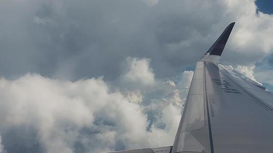 飞机起飞降落机场跑道工业化现代城市云层航行晴朗蓝天白云机翼多视角视频的预览图