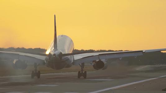 黄昏客机飞机降落到机场跑道轮胎摩擦地面升起烟雾视频的预览图