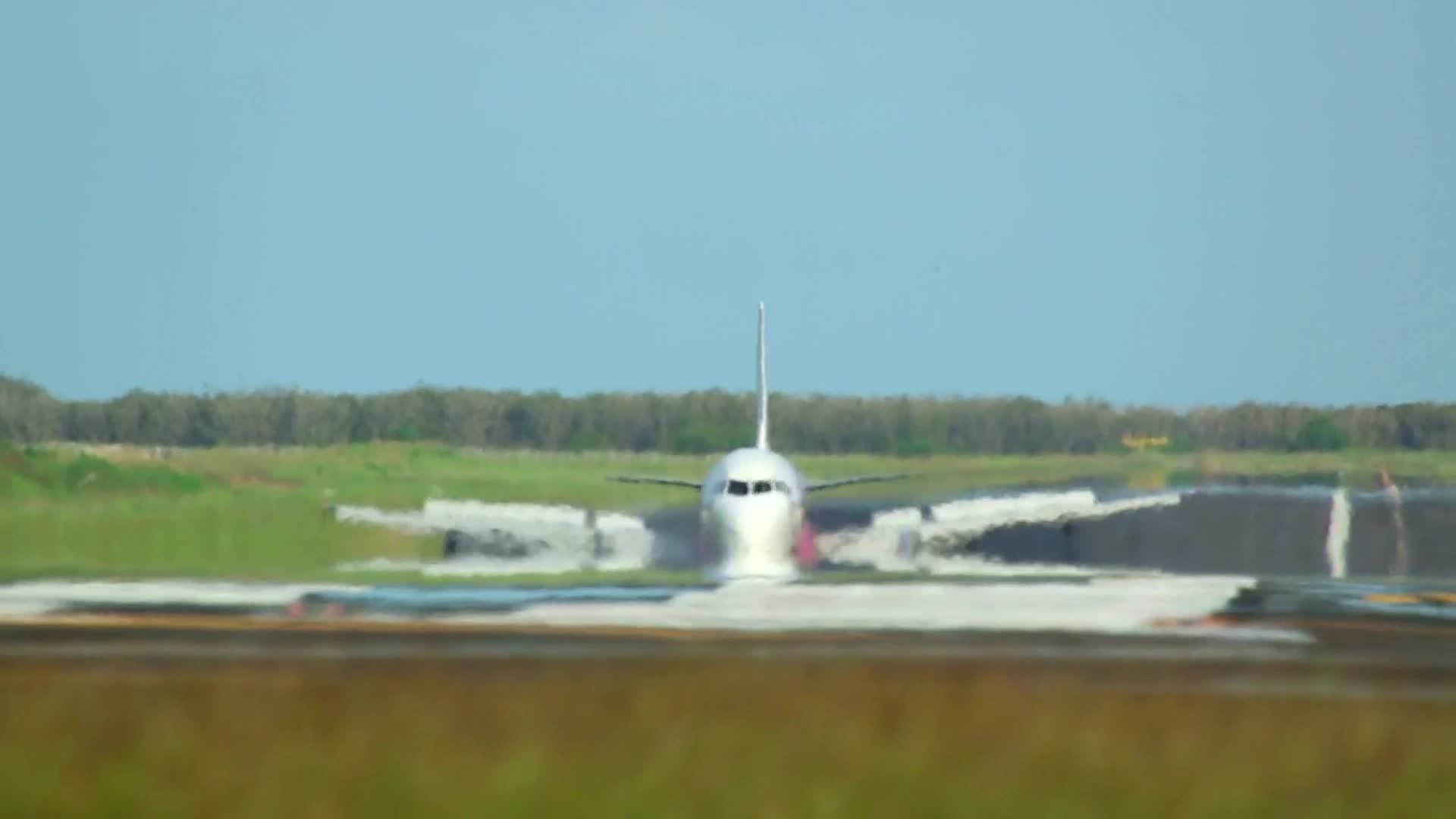 地面视角飞机客机在机场向前方驶来准备起飞形成热浪视频的预览图