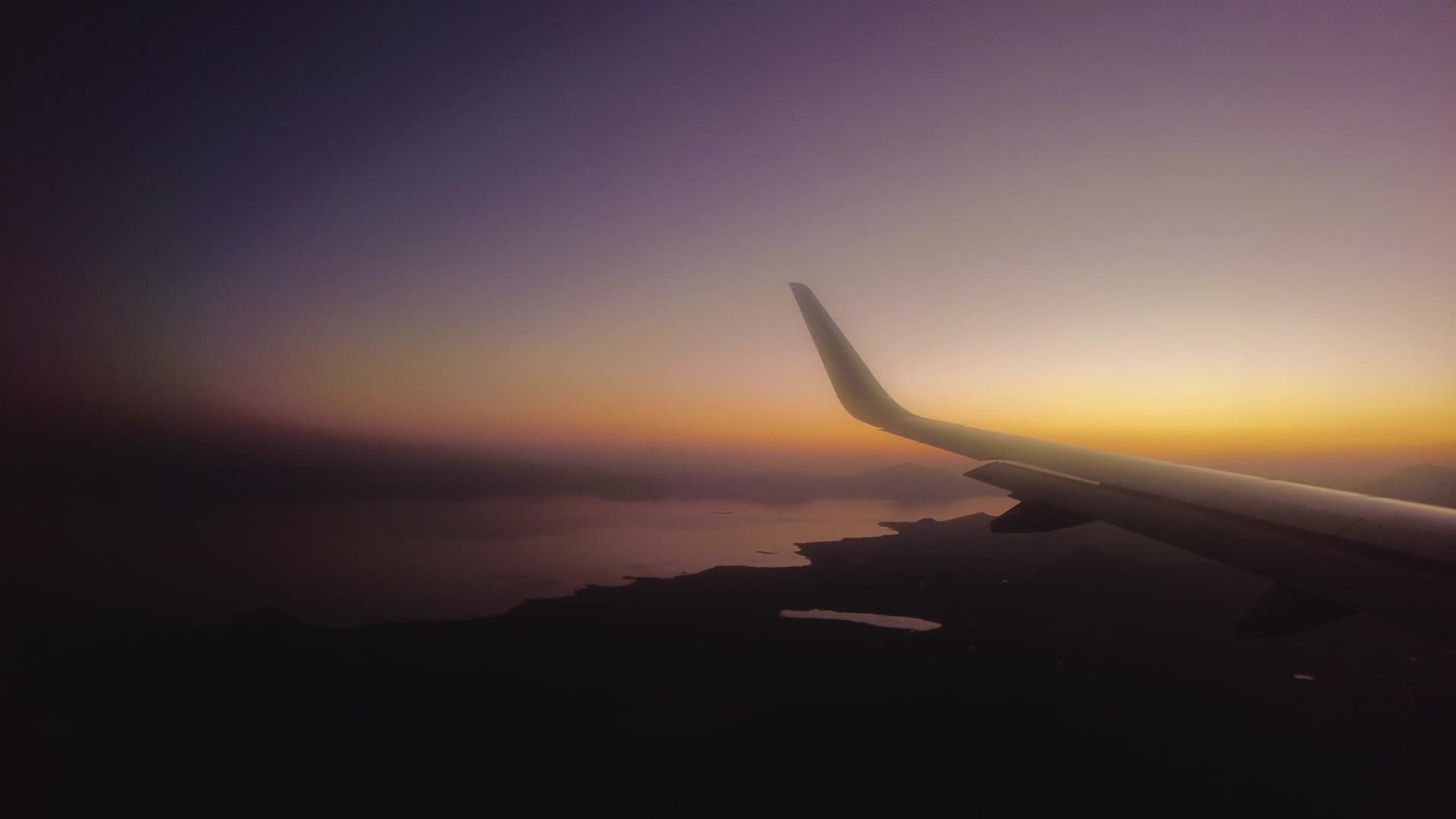 4K傍晚飞机飞行在云层之上机翼视角俯瞰大地视频的预览图