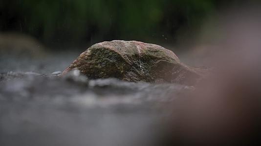 雨水拍打水面石块慢镜头视频的预览图