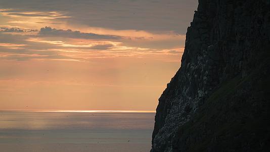 海面夕阳海鸟飞翔悬崖晚霞视频的预览图
