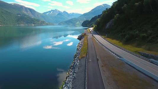 航拍风景春天大自然环境公路旁的湖泊远山雪峰视频的预览图
