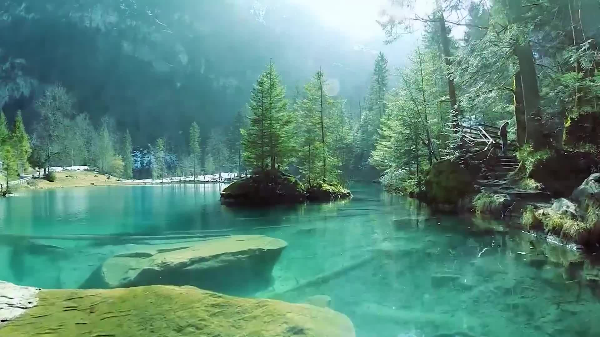 航拍风景自然风光环境逆光穿越树林山林间的碧绿湖泊类似九寨沟视频的预览图