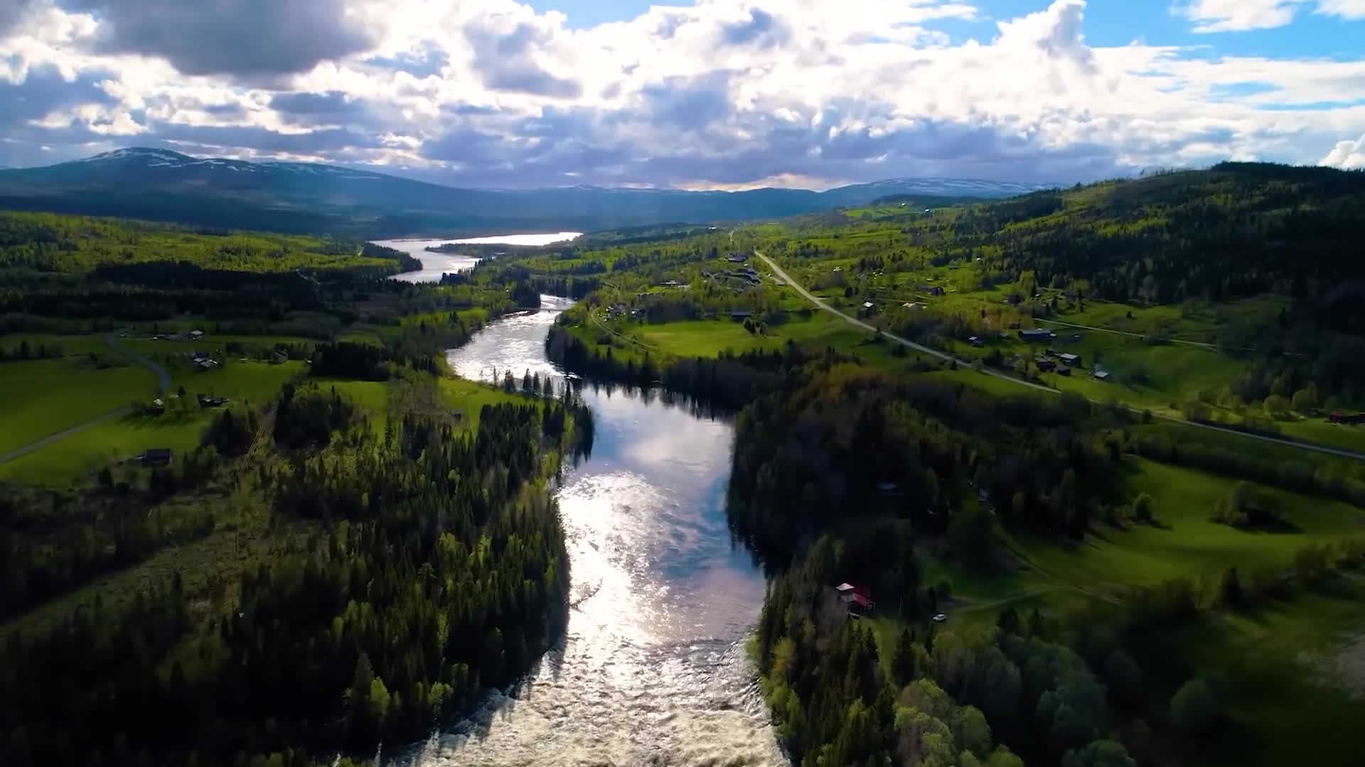 航拍风景自然风光环境阳光照耀下的河流穿村庄而过蓝天白云绿水青山视频的预览图