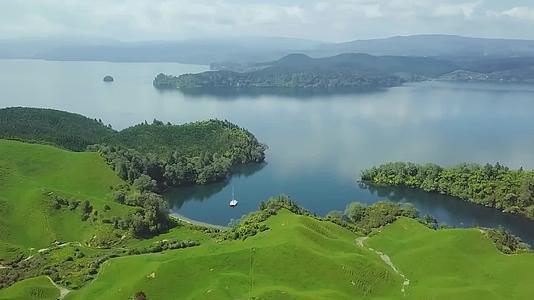 航拍风景自然环境草地平原高原游艇帆船停泊在湖泊行驶划过水面视频的预览图