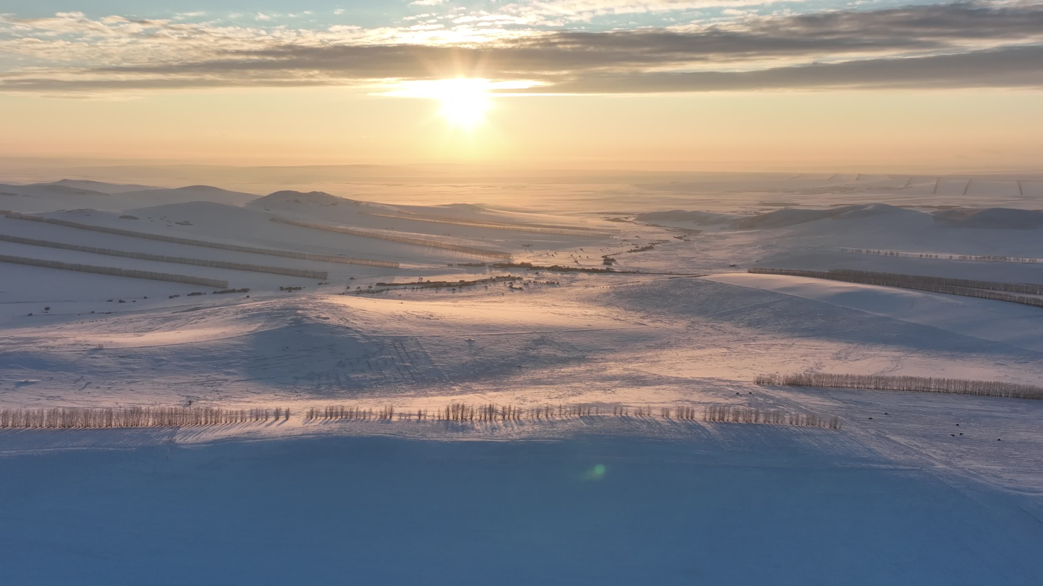 航拍冬季丘陵雪原黄昏夕阳视频的预览图