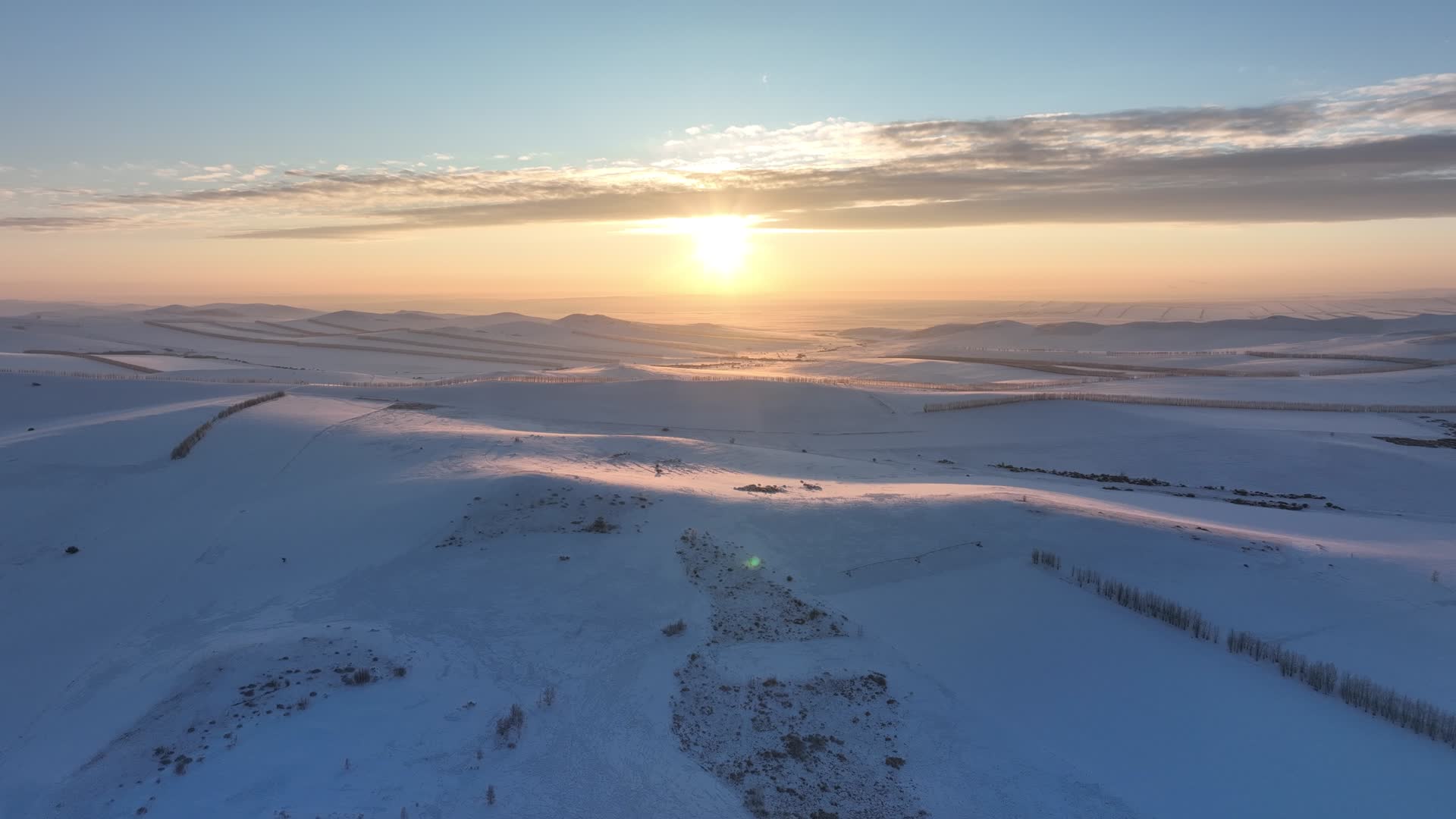 航拍冬季丘陵雪原黄昏夕阳视频的预览图