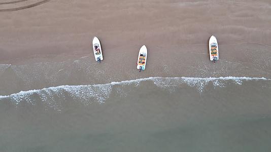 俯拍海边沙滩海浪游船视频的预览图