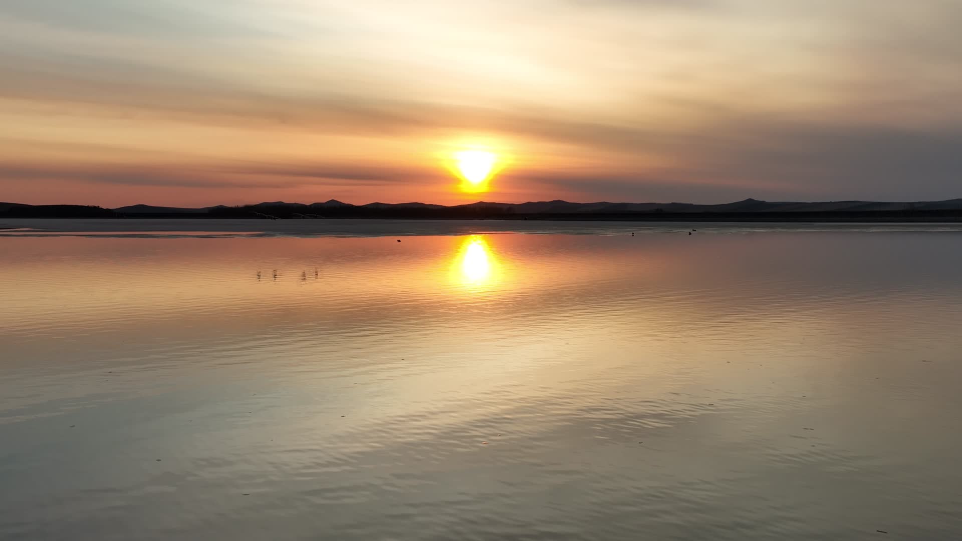 航拍水面水鸟浮冰夕阳晚霞视频的预览图