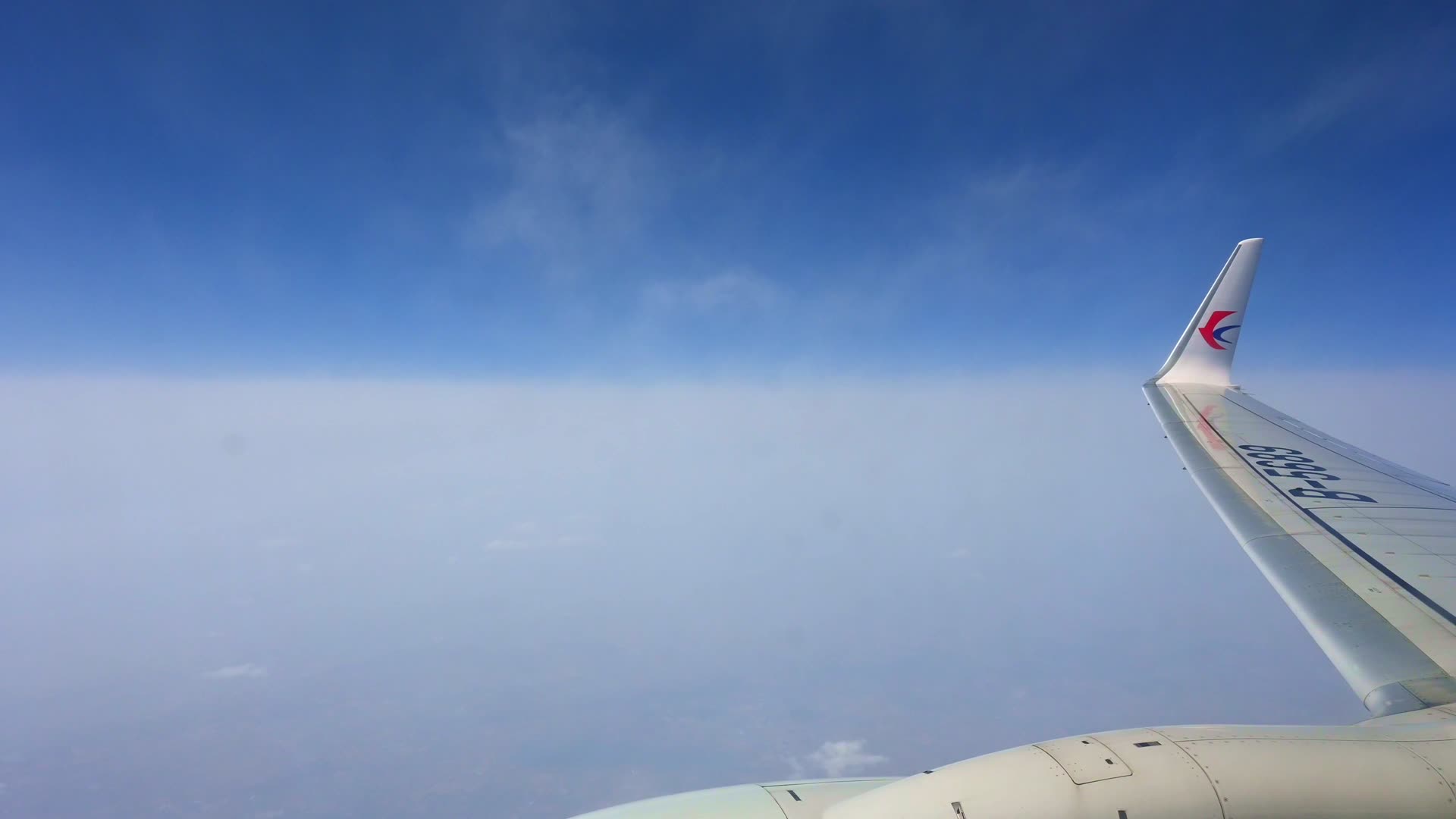 飞机飞行在云层之上透过舷窗俯瞰祖国大地视频的预览图