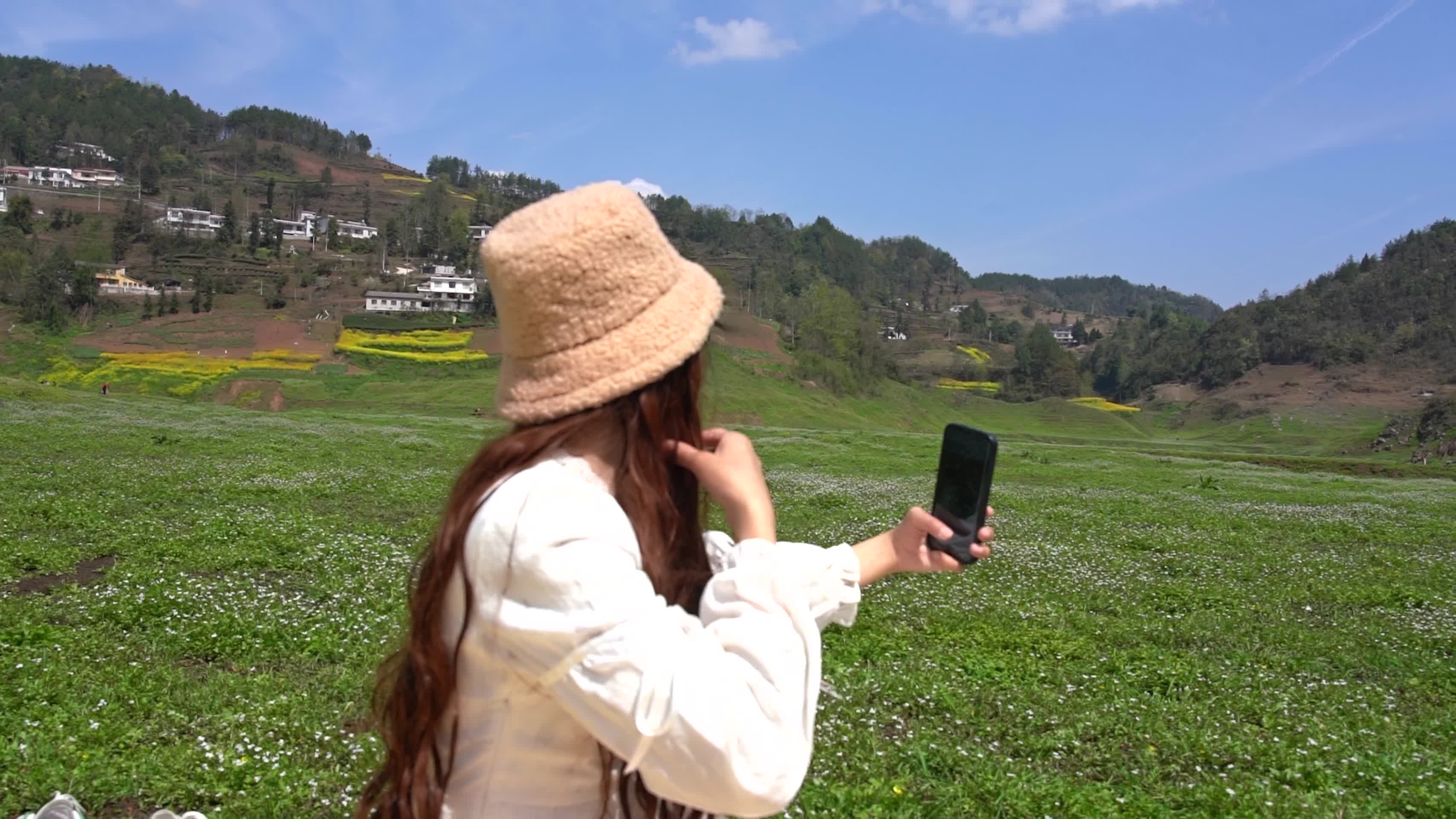 户外休闲活动少女手机玩自拍升格视频视频的预览图