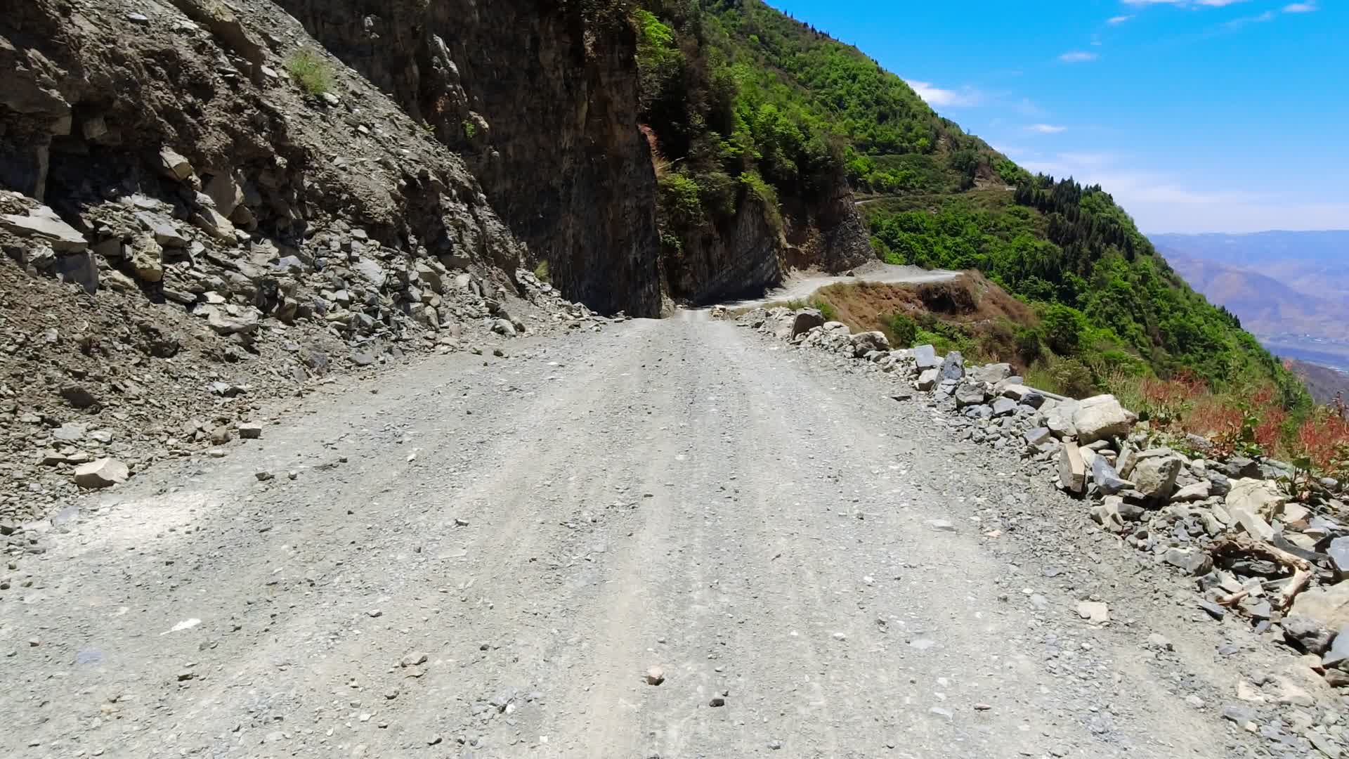 高山峡谷险峻崎岖的乡村盘山碎石土路视频的预览图