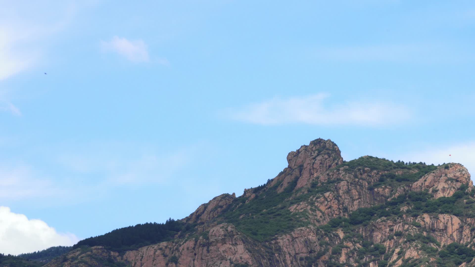 蓝天白云下的石头山峰视频的预览图