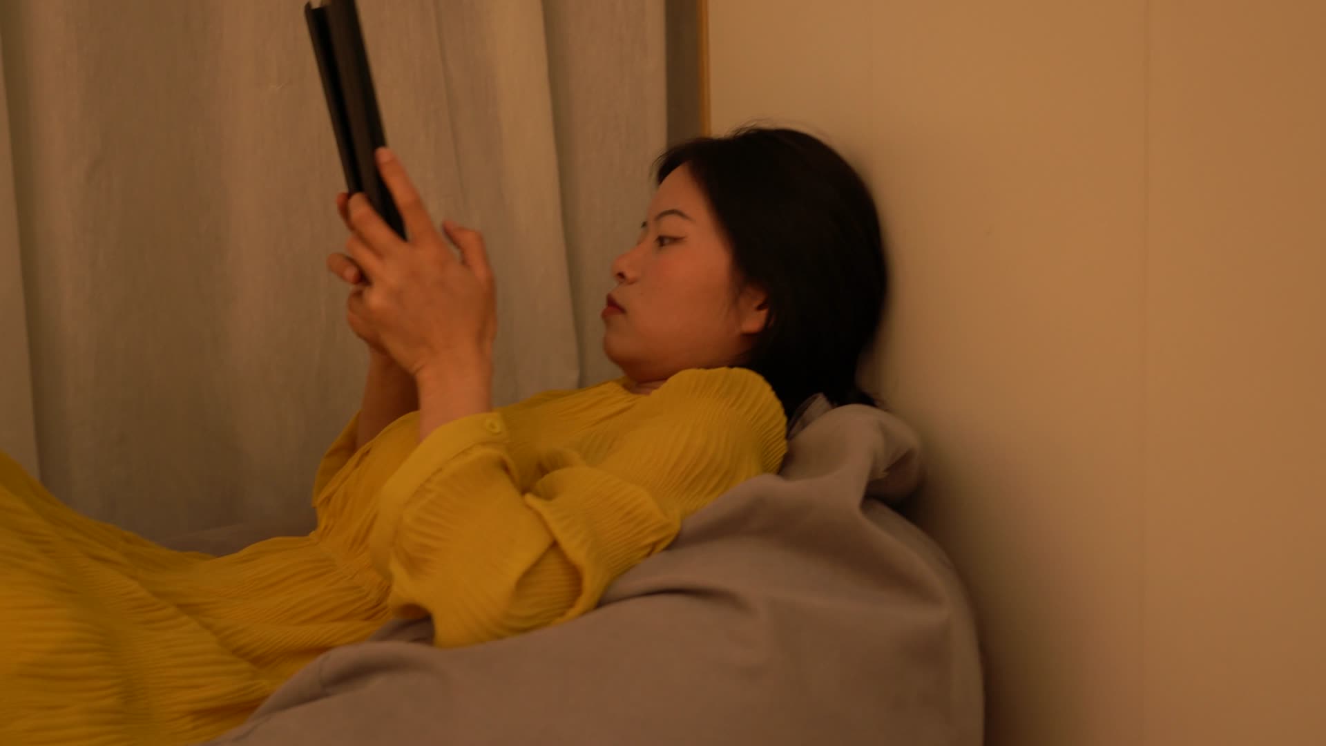 4K独居女性无聊躺在懒人沙发玩平板电脑视频的预览图