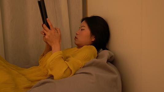 4K独居女性无聊躺在懒人沙发玩平板电脑视频的预览图