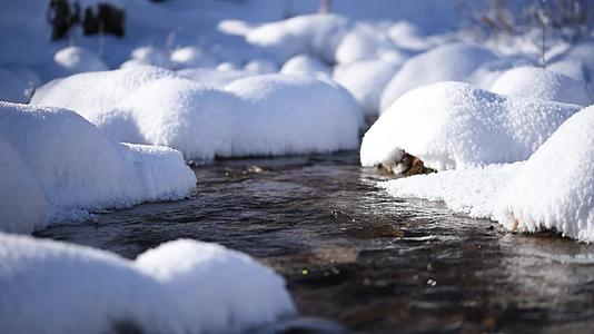 冬天雪地里的河流虚实焦转换特写视频的预览图