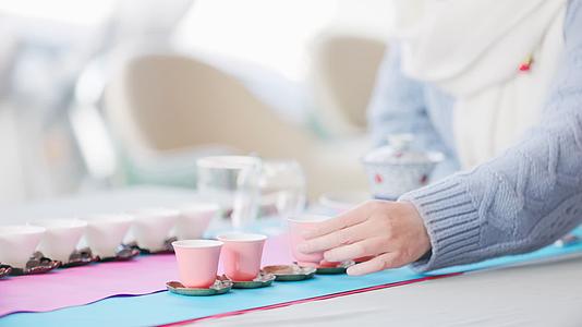 茶艺师拿起一个粉色茶杯视频的预览图