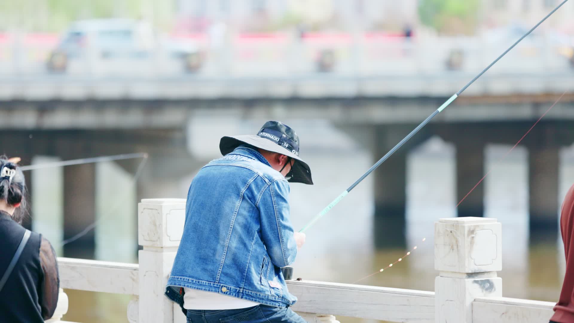 带着渔夫帽河边钓鱼的年轻人视频的预览图