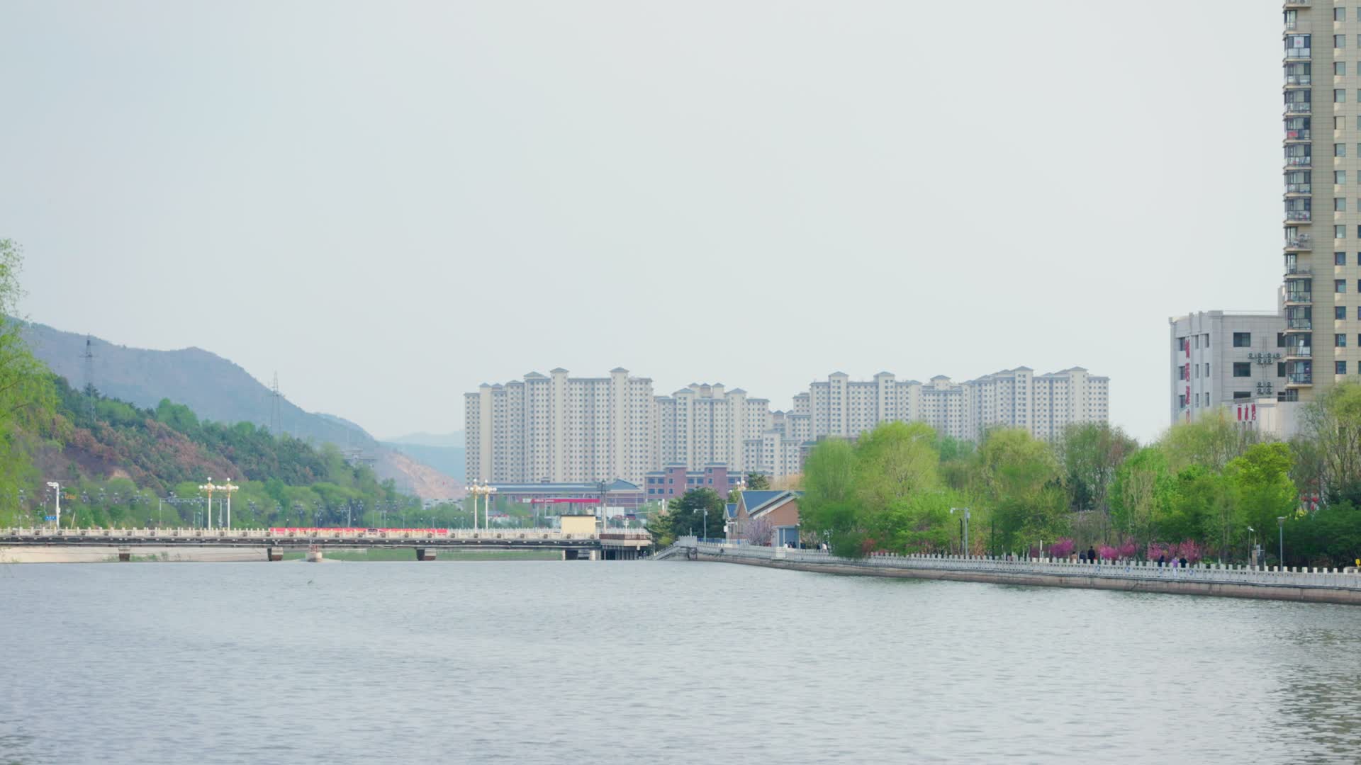 河道旁远处的高楼林立北方城镇视频的预览图