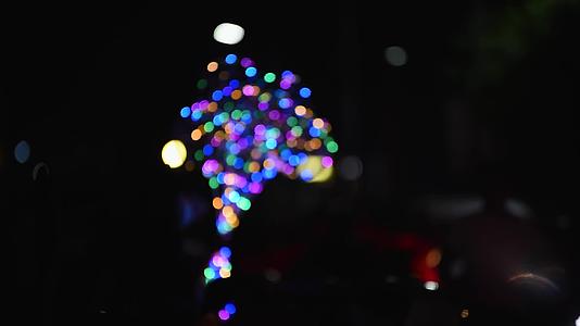 夜市上卖发光气球的人虚实焦变幻视频的预览图