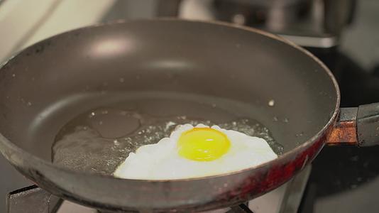 4K用锅铲翻动锅里的煎鸡蛋实拍视频视频的预览图