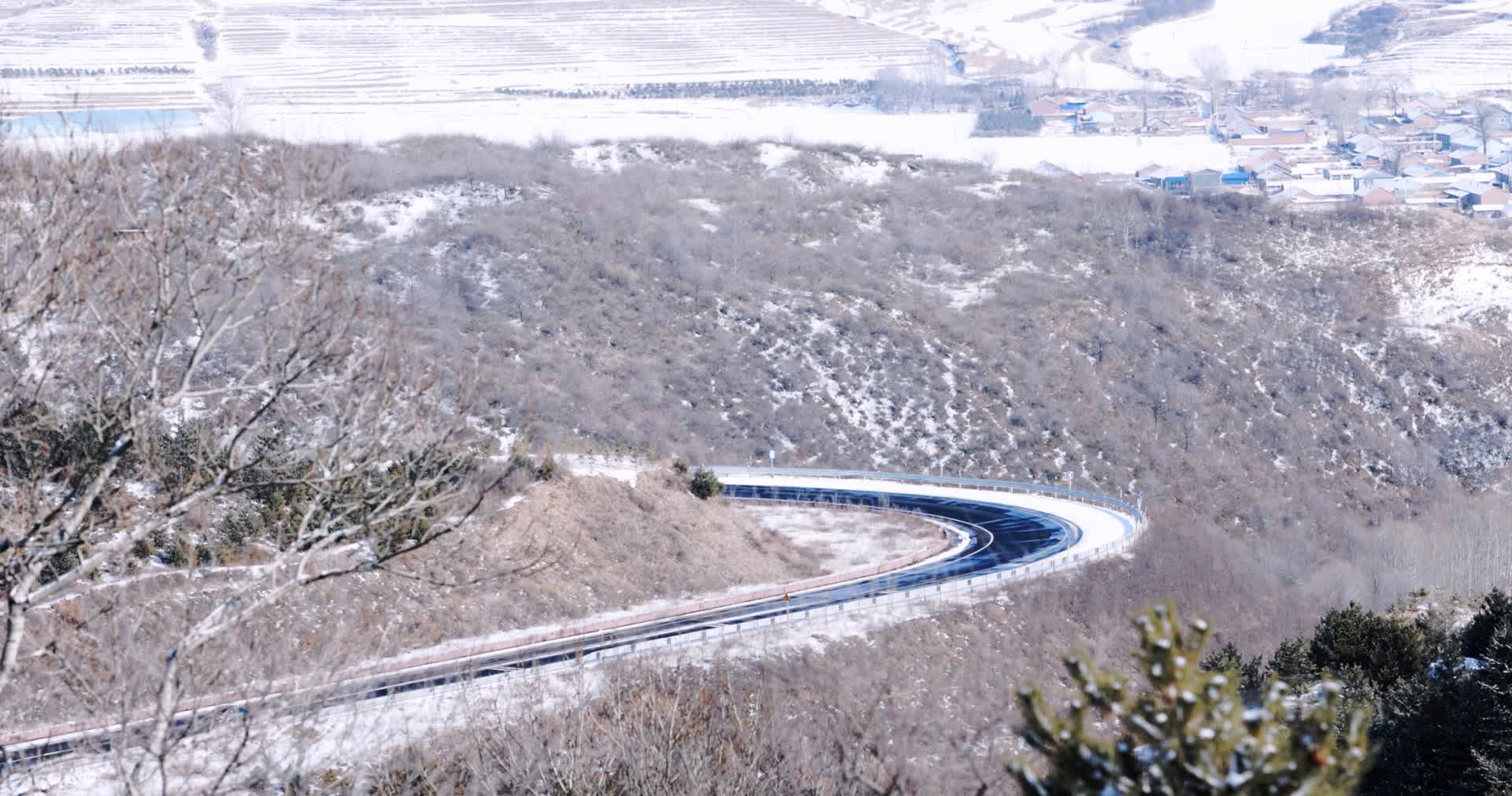 冬天大雪过后的蜿蜒山路汽车驶过视频的预览图