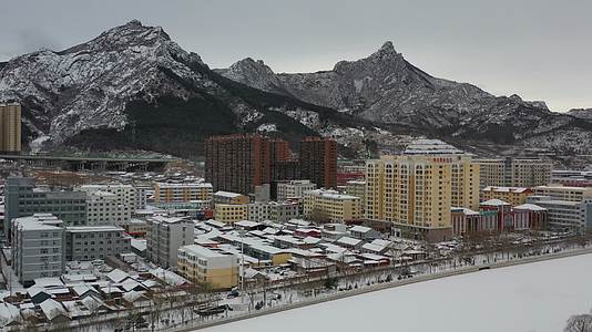 航拍雪后县城高山与高楼视频的预览图