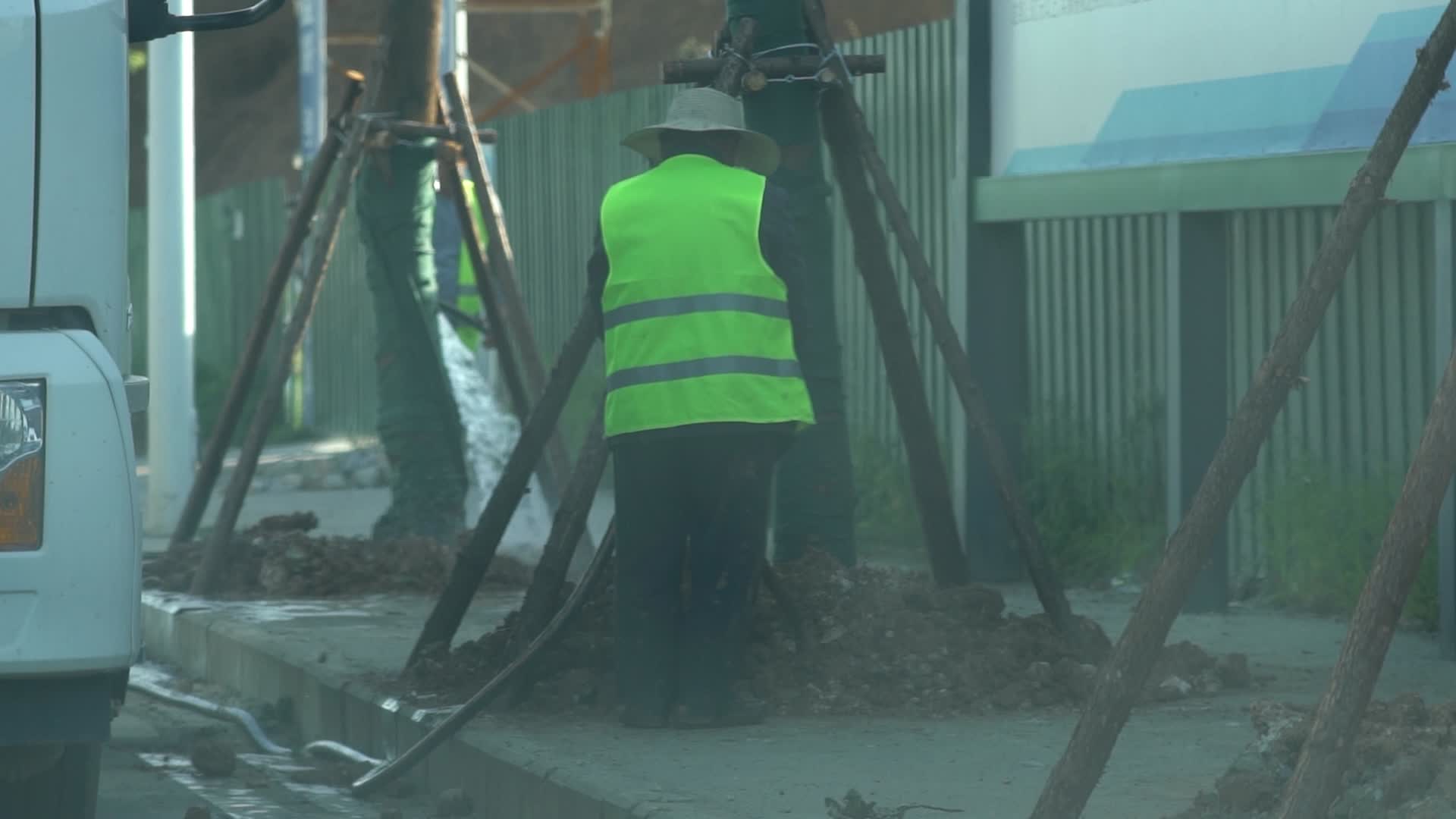4K城市路面绿化劳动人员背影实拍视频视频的预览图