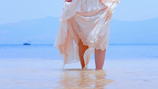 海边沙滩上光着脚丫行走在浅滩的姑娘视频的预览图