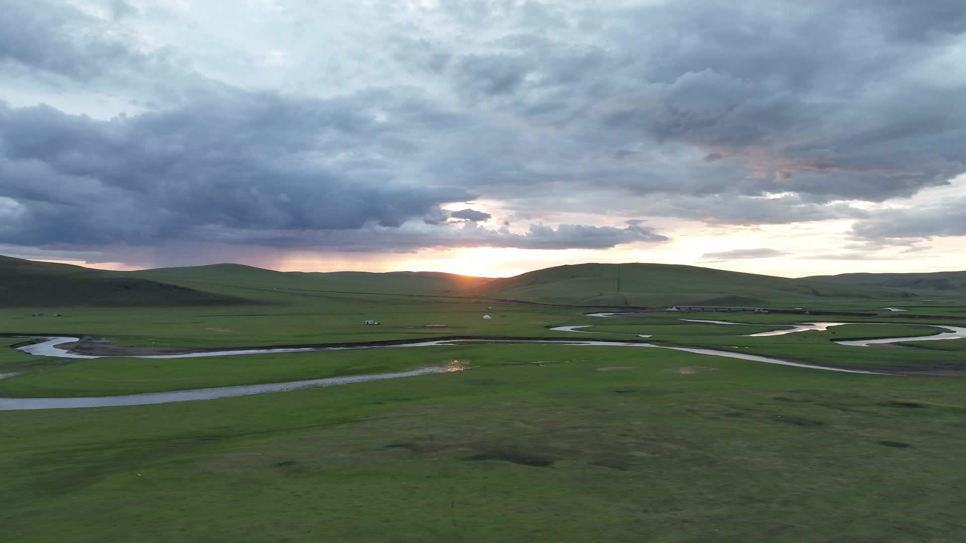 航拍初夏绿色草原弯曲河流天空彩云落日余晖视频的预览图