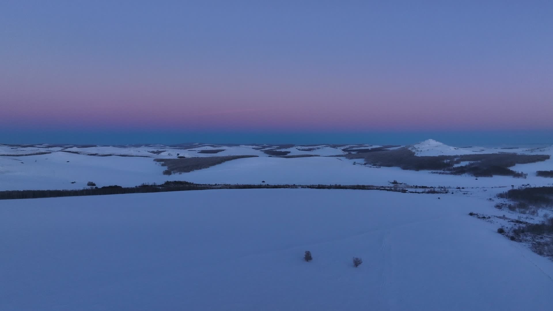 冬季航拍雪野雪原落日余晖一抹晚霞视频的预览图