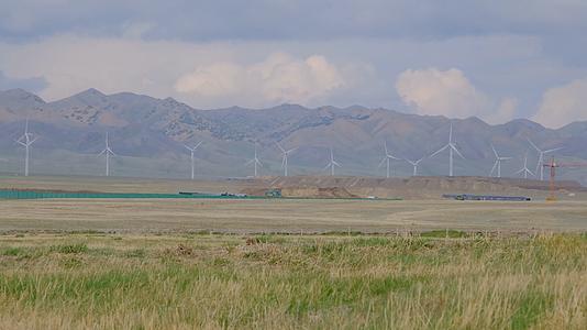 新疆天山脚下草原上的风车风力发电机视频的预览图