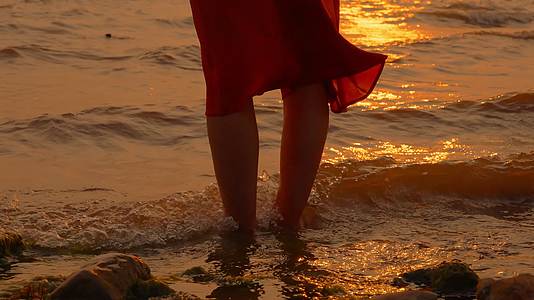金光闪闪的晚霞海边美女光着脚玩水视频的预览图