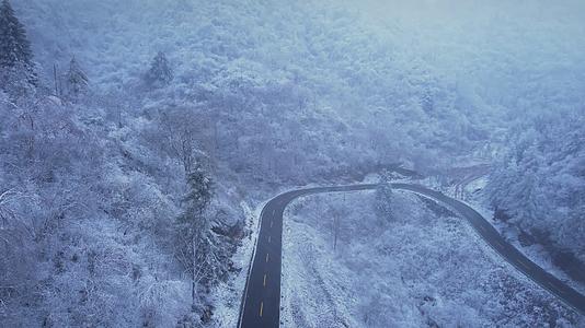 4K冬季下雪山上的道路航拍视频视频的预览图