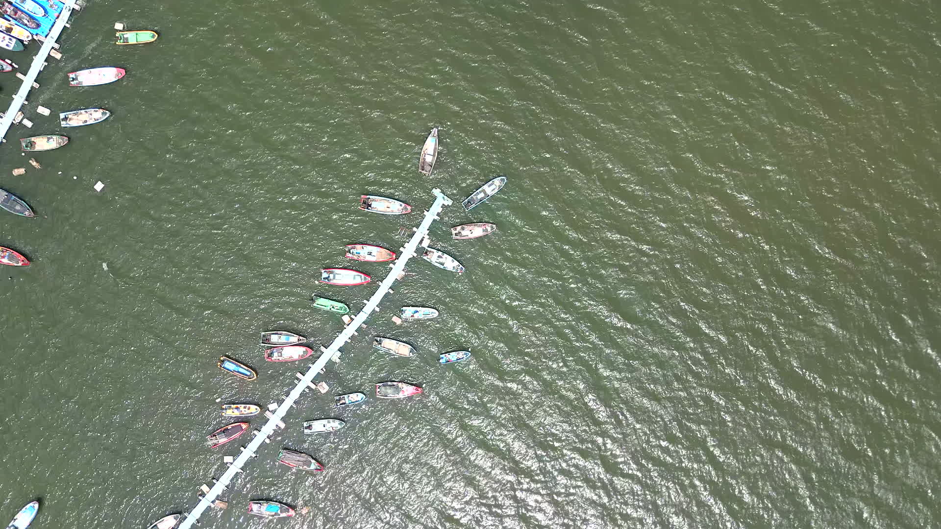 夏日晴天航拍海边停泊的五彩小船视频的预览图